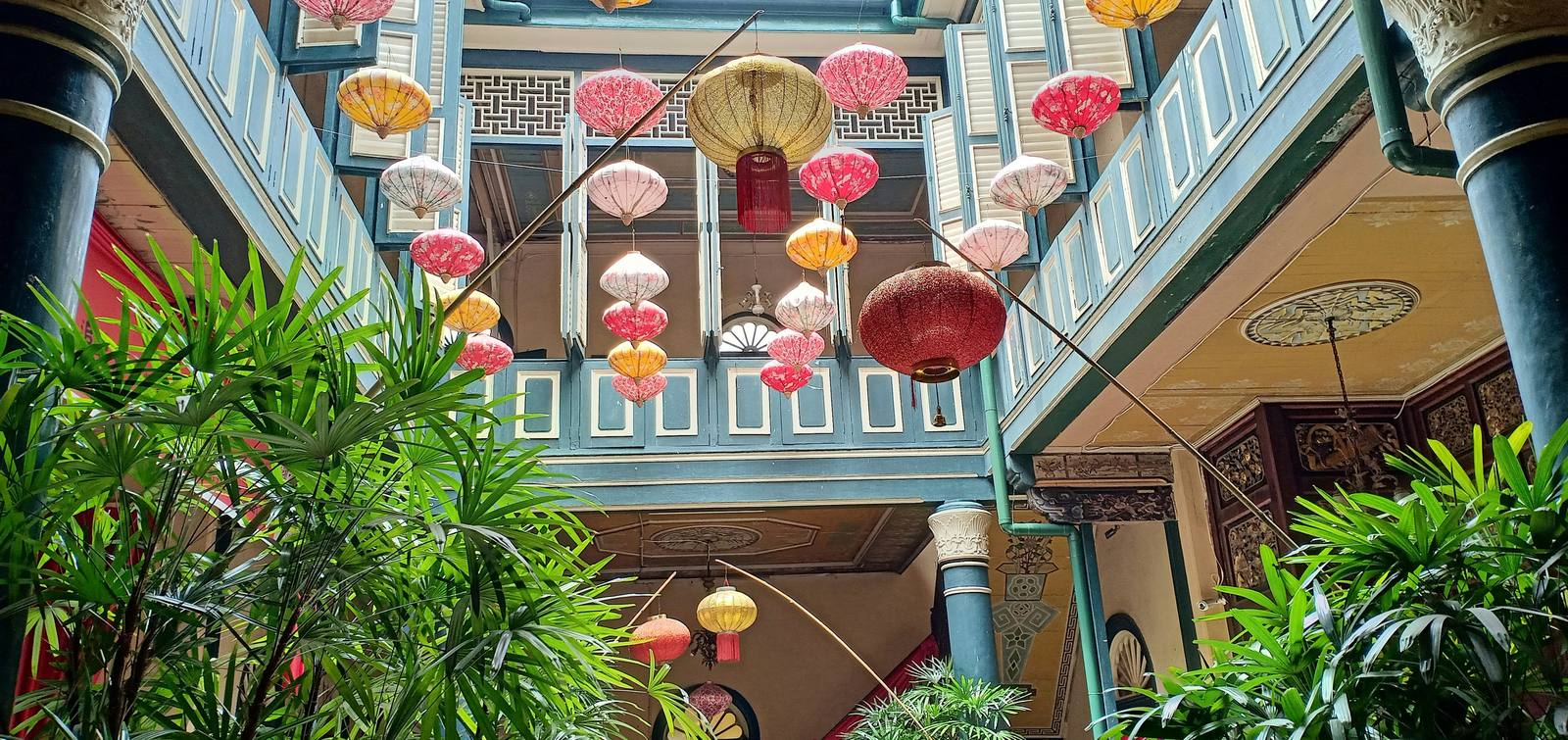 Peranakan lanterns hanging in a heritage townhouse courtyard